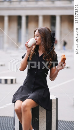 Chic woman having coffee and croissant in Paris 125375291