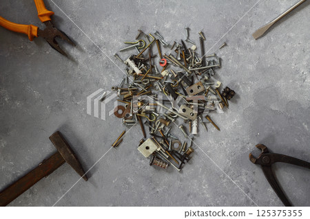 Hammer, wrench, gloves, and other worn and dirty tools on stone background with copy space Hammer, wrench, gloves, and other worn and dirty tools on stone background with copy space 125375355