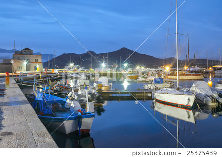 Exciting sunset view on boats in beautiful marina of Villasimius. 125375439