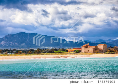 Astonishing view on  Nora bay and beach, the medieval Sant Efisio church near the shore. 125375503