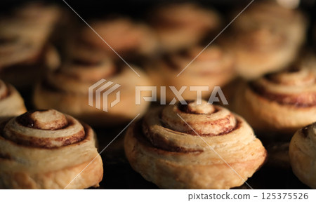 Close-up of freshly baked cinnamon rolls in the oven. Close-up of freshly baked cinnamon rolls in the oven. 125375526