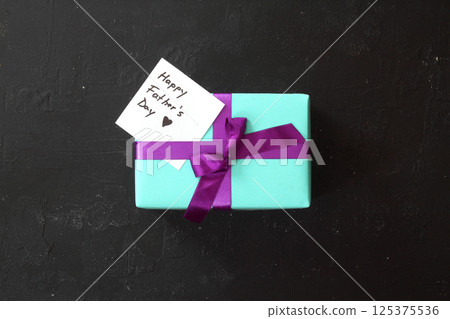 Blue gift box on black background. Happy father's day concept. Greeting card 125375536