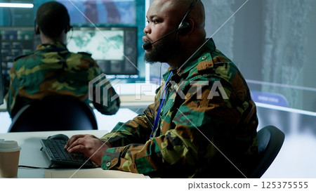 Military control room features army personnel monitoring surveillance systems, soldiers integrating data and coordinating strategic missions. Support decision making and efficiency. Camera A. 125375555