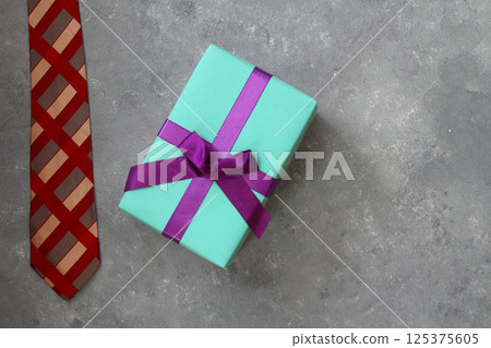 Fathers day concept with red dress tie and gift box on stone background in flat lay format 125375605