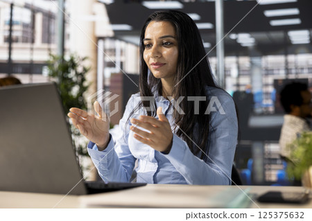 Professional indian worker leads a teleconference with team members, discussing project details and strategic objectives. Virtual meeting ensures efficient business communication across locations. Professional indian worker leads a teleconference with team members, discussing project details and strategic objectives. Virtual meeting ensures efficient business communication across locations. 125375632