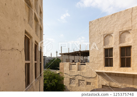 Old town in Al Seef Cultural Historical District on shores of Dubai Creek. Tourist place with old streets, houses and shops, Dubai, UAE Old town in Al Seef Cultural Historical District on shores of Dubai Creek. Tourist place with old streets, houses and shops, Dubai, UAE 125375748
