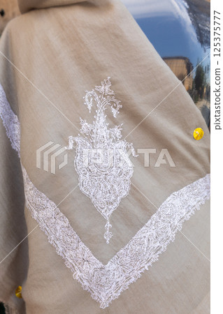 Beautiful embroidery in form of white flower on cotton shawl. High quality photo 125375777