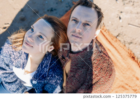 Portrait loving couple walks on beach along sea on sunny autumn day. Weekend and lifestyle concept. High quality photo 125375779