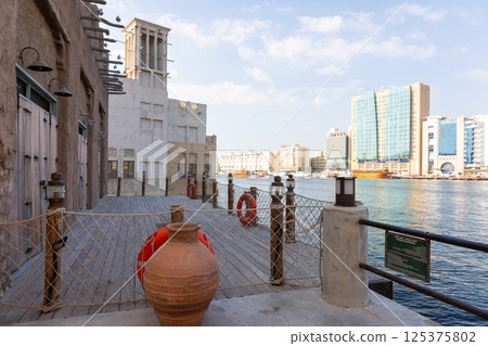 Old town in Al Seef Cultural Historical District. Beautiful view of water, old houses and new ones of Dubai Creek, Dubai, UAE. Taken off hand. High quality photo 125375802