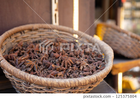 Traditional spices market. Pots and wooden tubs stand with star anise spice. Street bazaar. Dubai, UAE.  125375804