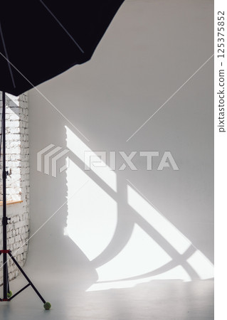 Clear white cyclorama. Light background with with professional lighting equipment. Plain wall empty photo studio. Vertical photo. 125375852