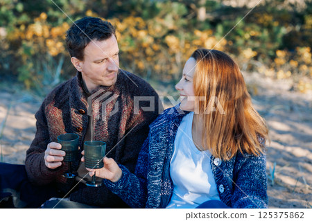 Portrait happy beautiful couple in love enjoying autumn picnic in autumn park. High quality photo 125375862