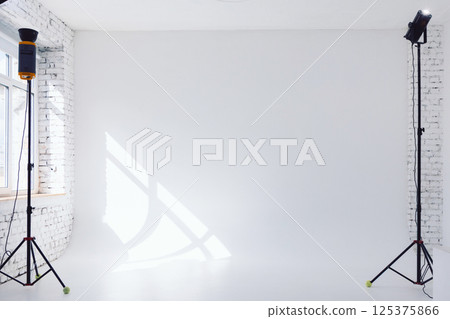 Clear white cyclorama. Light background with with professional lighting equipment. Plain wall empty photo studio 125375866