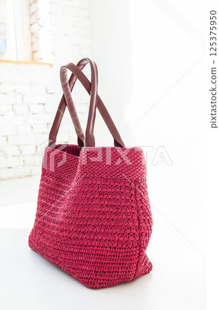 Fashionable red woven bag on light background. Fashion and luxury accessories. Vertical photo. High quality photo Fashionable red woven bag on light background. Fashion and luxury accessories. Vertical photo. High quality photo 125375950