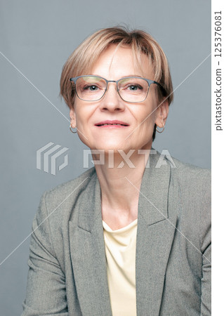 Portrait of happy woman. Confident, successful mature woman on light gray background. Looking at camera. High quality photo 125376081