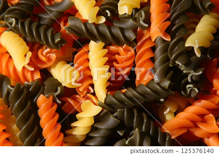Colorful various raw fusilli on black plate Colorful various raw fusilli on black plate 125376140