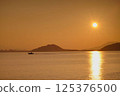 Sunset over Mount Kaya and the silhouette of a fishing boat 125376500