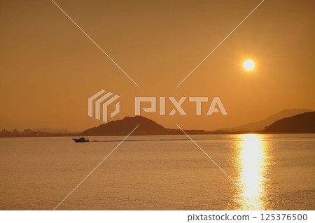 Sunset over Mount Kaya and the silhouette of a fishing boat Sunset over Mount Kaya and the silhouette of a fishing boat 125376500