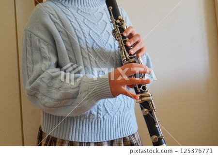 A fifth grade elementary school student who has been playing the clarinet for 1 year and 11 months practices the clarinet. A fifth grade elementary school student who has been playing the clarinet for 1 year and 11 months practices the clarinet. 125376771