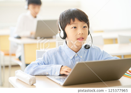 小學生戴著耳機學習 |連結線上與課堂的混合課程 小學生戴著耳機學習 |連結線上與課堂的混合課程 125377965
