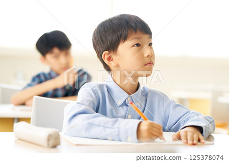 Male elementary school student studying in the classroom | Thinking expression Male elementary school student studying in the classroom | Thinking expression 125378074