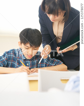 An elementary school boy learning from his teacher | An educational setting that values dialogue An elementary school boy learning from his teacher | An educational setting that values dialogue 125378077