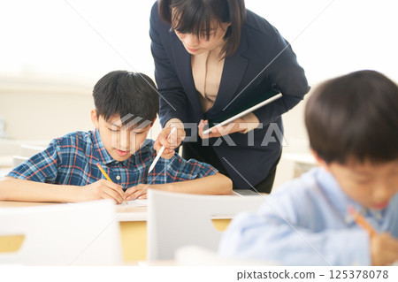 一位小學生正在向老師學習 |重視對話的教育環境 一位小學生正在向老師學習 |重視對話的教育環境 125378078