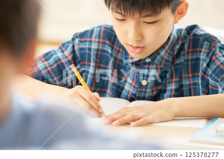 小學生專心寫字 |專心學習的嚴肅表情 125378277