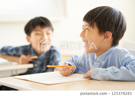 Elementary school boys laughing in the classroom 125378283