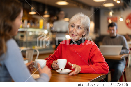 Elderly woman meets her adult daughter in cafe. Conversation over cup of coffee 125378706