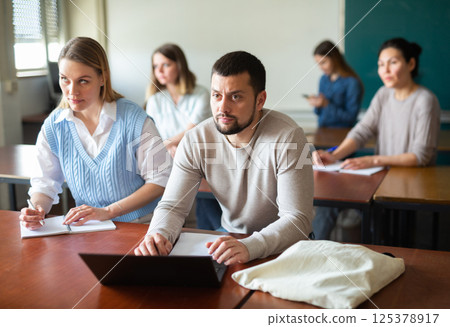 University students exercising in class room University students exercising in class room 125378917