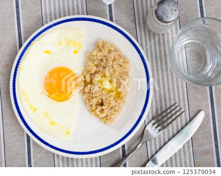 Oatmeal with two fried eggs top view Oatmeal with two fried eggs top view 125379034