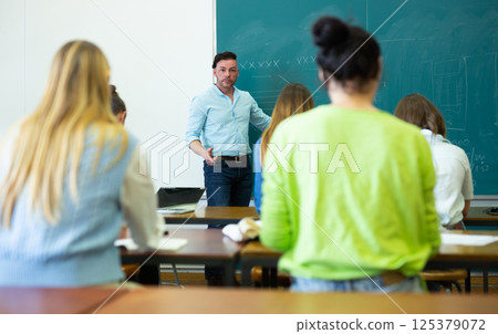 Young teacher is giving a lecture to students Young teacher is giving a lecture to students 125379072