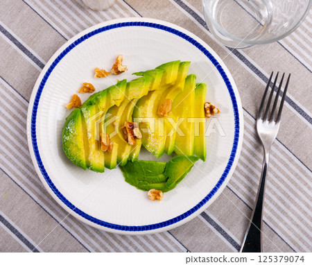 Sliced avocado served with walnuts Sliced avocado served with walnuts 125379074