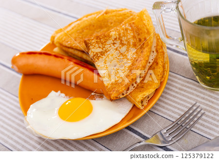 Tasty pancakes with scrambled eggs and sausage. Healthy breakfast Tasty pancakes with scrambled eggs and sausage. Healthy breakfast 125379122