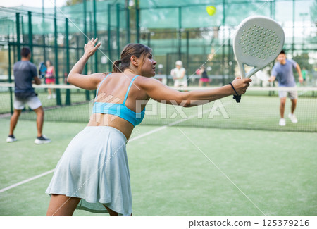 Attractive woman padel tennis player training on court Attractive woman padel tennis player training on court 125379216