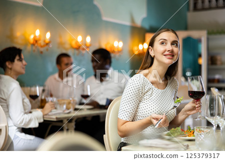 Girl sitting in restaurant Girl sitting in restaurant 125379317