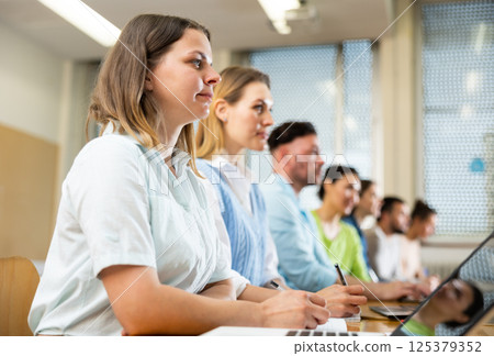 Side view of group of adult students in university classroom Side view of group of adult students in university classroom 125379352