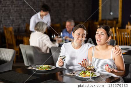 Sad upset young woman shares with female friend about difficult period of relations with boyfriend Sad upset young woman shares with female friend about difficult period of relations with boyfriend 125379383