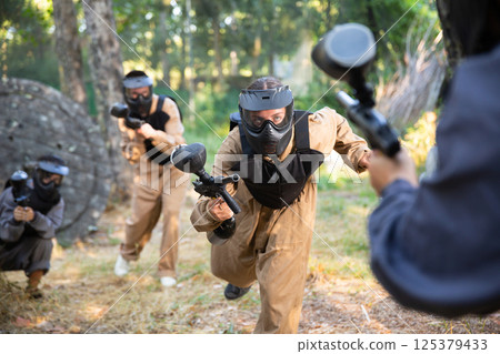 Team of paintball players attacks enemy at an army training ground 125379433