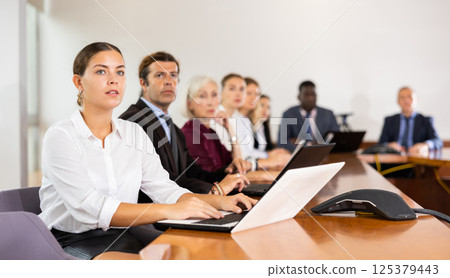 Young woman secretary typing on laptop during conference 125379443