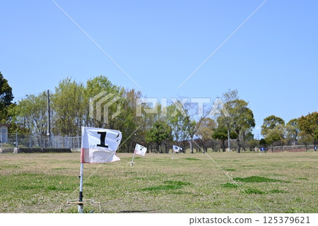 Grand golf hole flag fluttering in the wind Grand golf hole flag fluttering in the wind 125379621