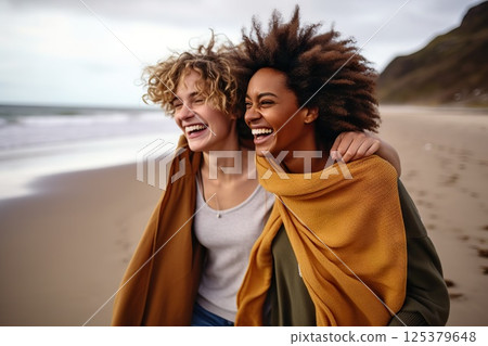 Oceanic Bonds Joyful Embrace of Two Women on a Breezy Beach, Laughter Echoing Waves, Windswept Hair, and Warm Scarves Unveiling Deep Connections. created with Generative AI 125379648