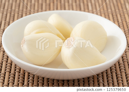 Peeled garlic on a small plate Peeled garlic on a small plate 125379650
