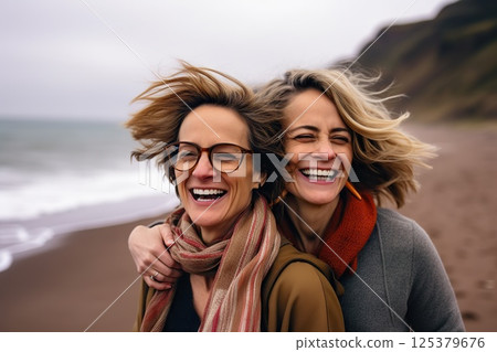 Oceanic Bonds Joyful Embrace of Two Women on a Breezy Beach, Laughter Echoing Waves, Windswept Hair, and Warm Scarves Unveiling Deep Connections. created with Generative AI 125379676