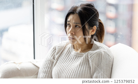 woman feel doubt and sit in the living room 125379852