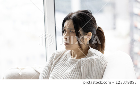 woman feel doubt and sit in the living room woman feel doubt and sit in the living room 125379855