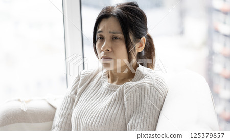 woman feel doubt and sit in the living room 125379857