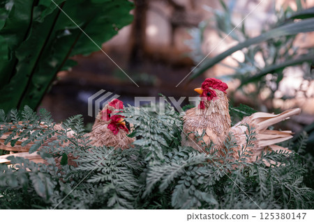 Handmade decorative chicken figure in garden setting. Spring and Easter symbol Handmade decorative chicken figure in garden setting. Spring and Easter symbol 125380147