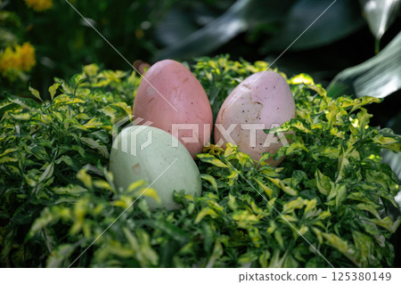 Pastel Easter eggs hidden in green foliage with yellow flowers. symbolizing spring celebration 125380149